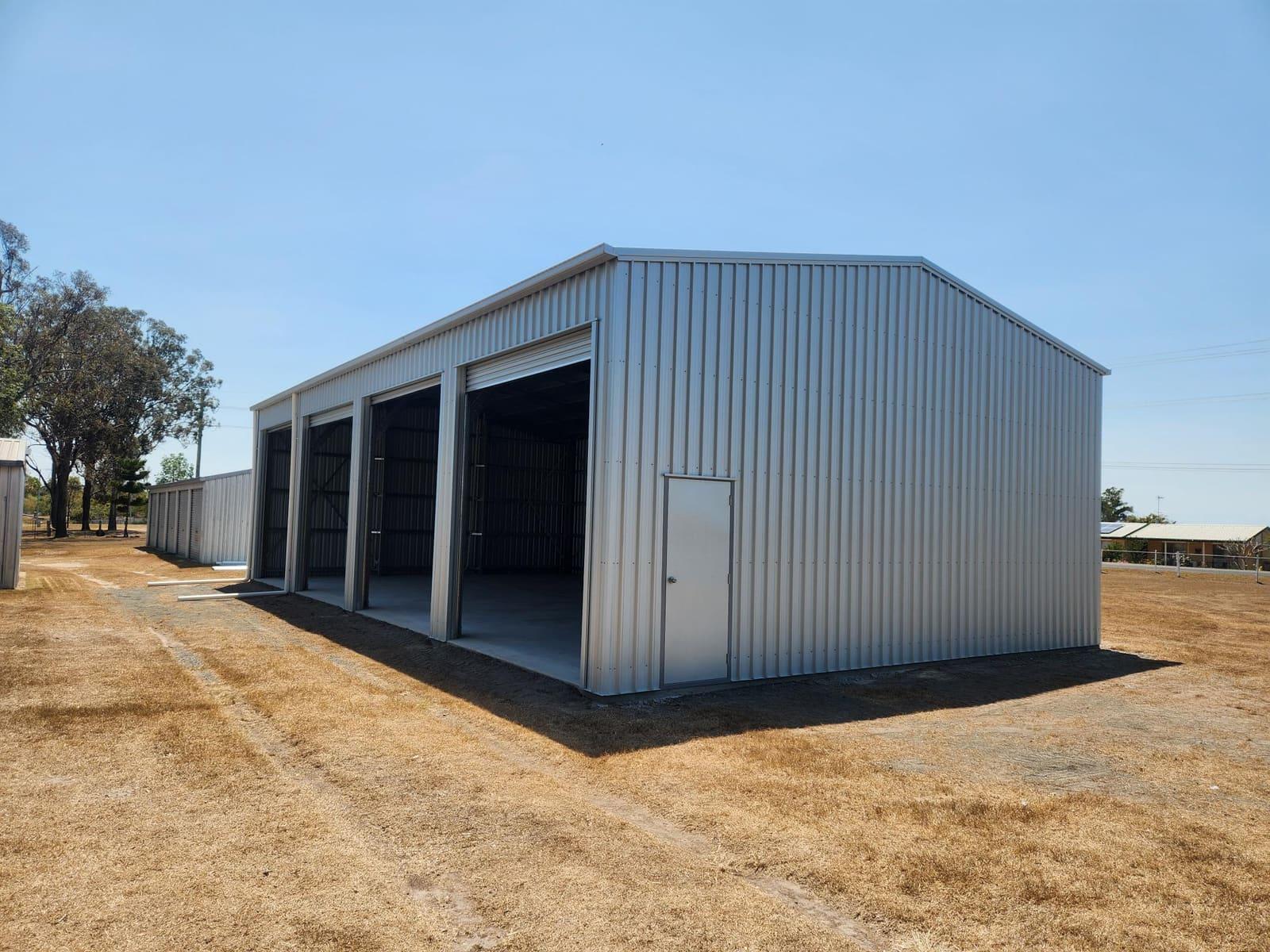 Tall zincalume three-bay enclosed shed with roller doors and a personal access door