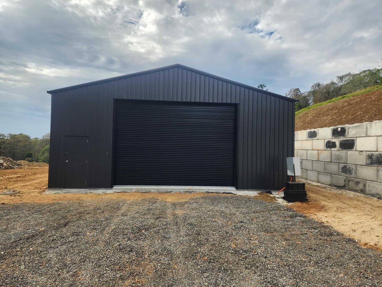 Black steel shed from the front with roller and access doors